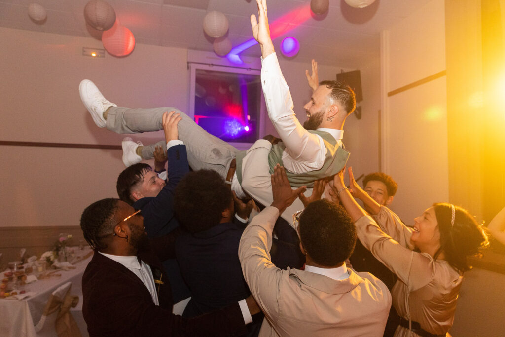 Porté du marié sur la piste de danse par ses amis