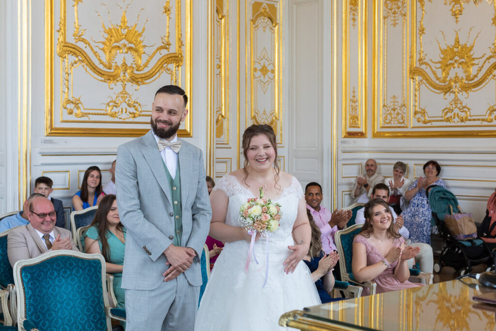 Mariés sourient dans la salle de mariage de la mairie de Versailles