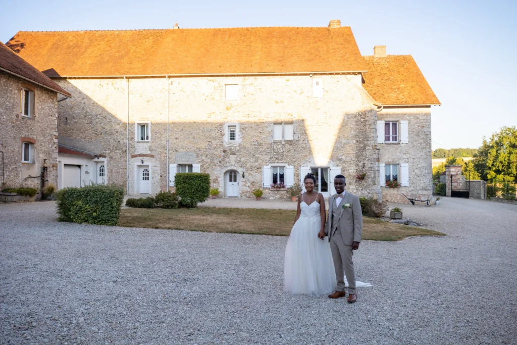 Les mariés devant la façade en pierre de L'Étable de Véronge à La Chapelle-Moutils