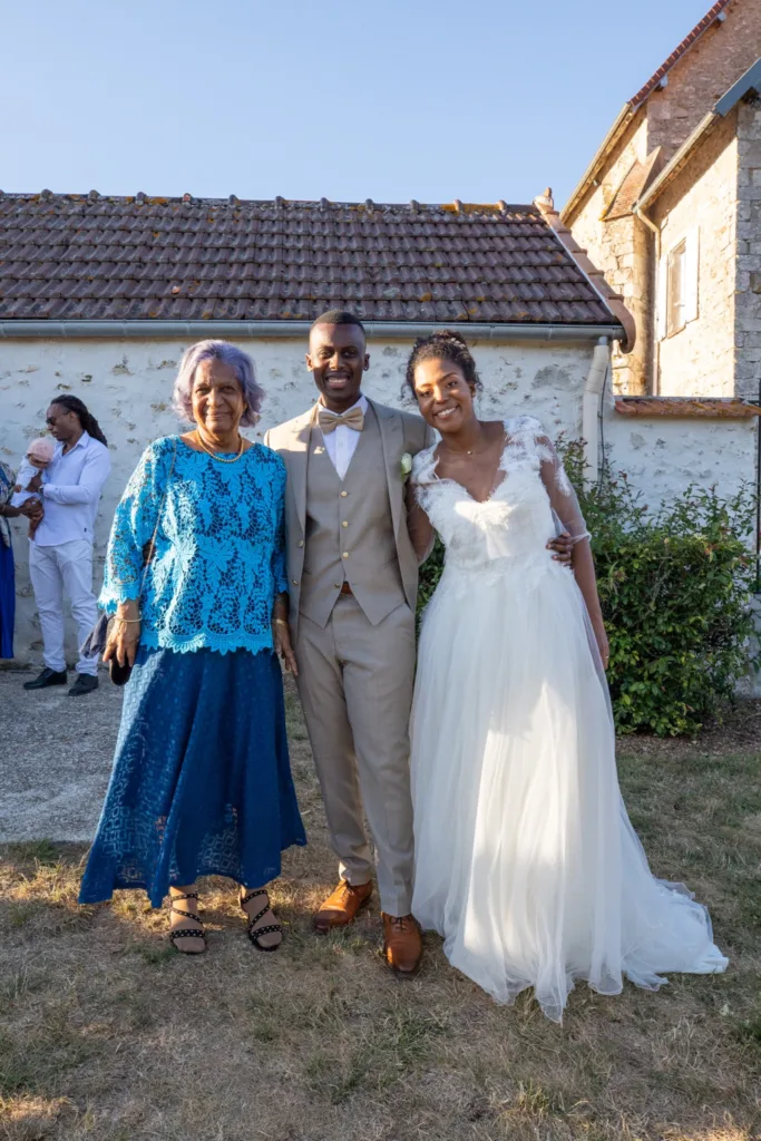 Les mariés avec une proche dans le jardin de L'Étable de Véronge