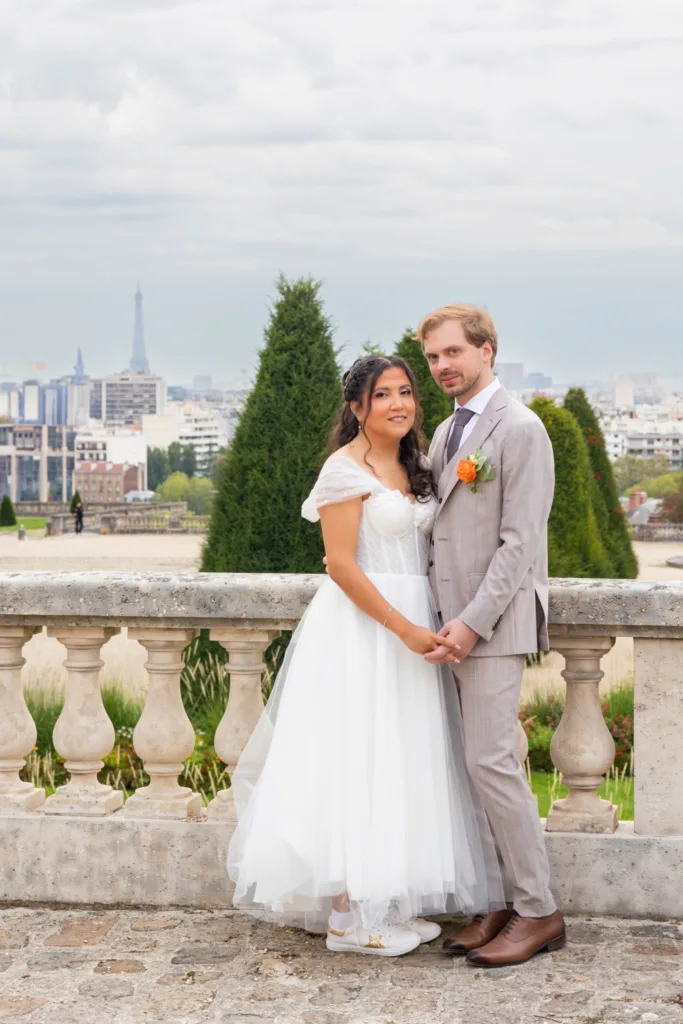 Photo de couple devant la balustrade, tour Eiffel en arrière-plan, mariage à Saint-Cloud