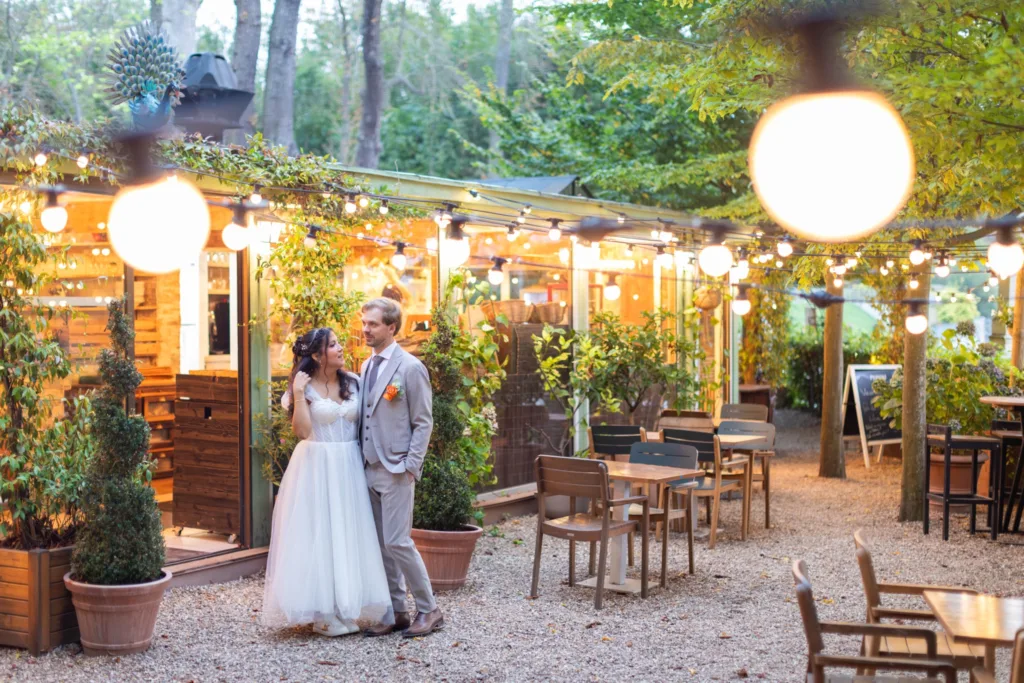 Les mariés devant la terrasse illuminée de l'Orangerie de Saint-Cloud en soirée