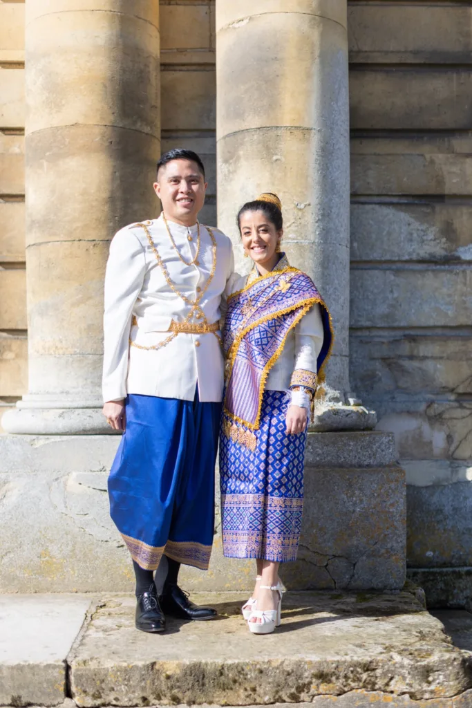 Mariés en tenue traditionnelle laotienne devant les colonnes du Château de Champlâtreux