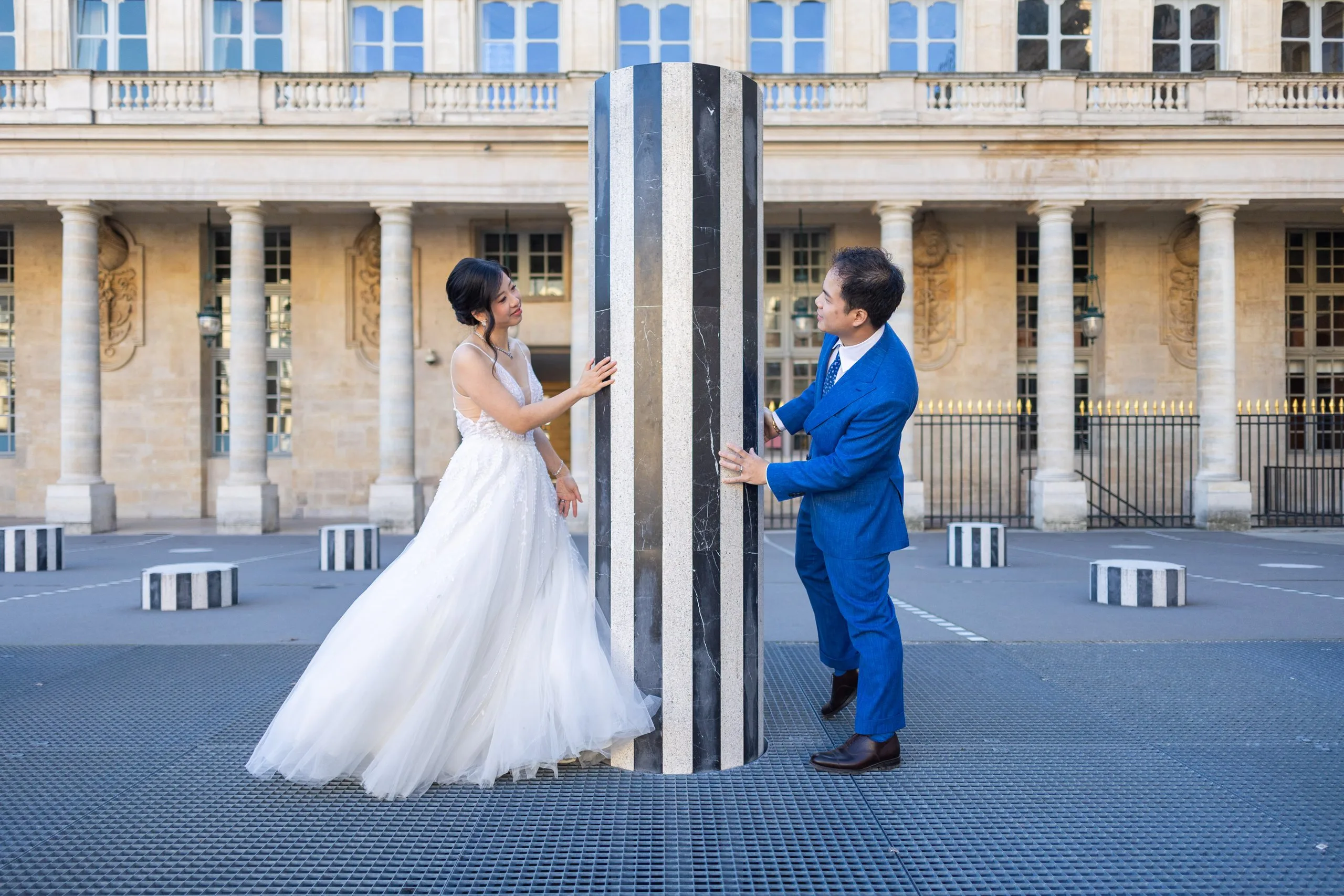 Mariés jouant autour d'une colonne de Buren au Palais-Royal à Paris