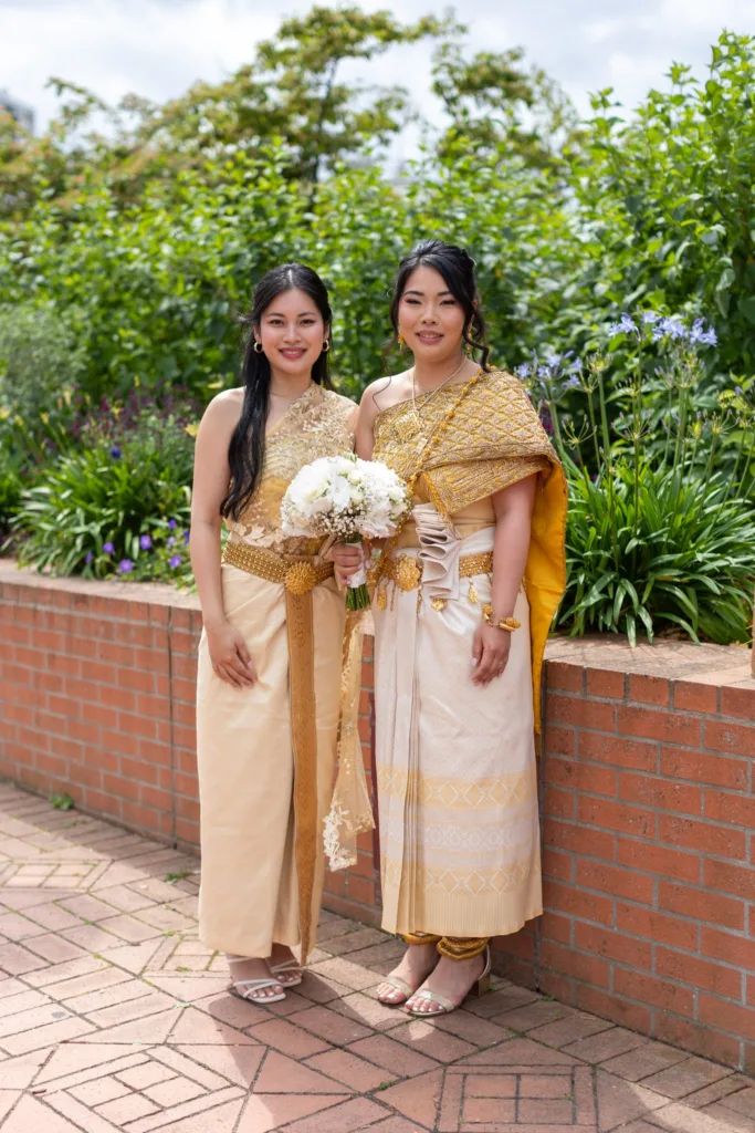 Monita, mariée en tenue traditionnelle cambodgienne dorée, avec une proche en tenue khmère le jour du mariage civil à Vitry-sur-Seine