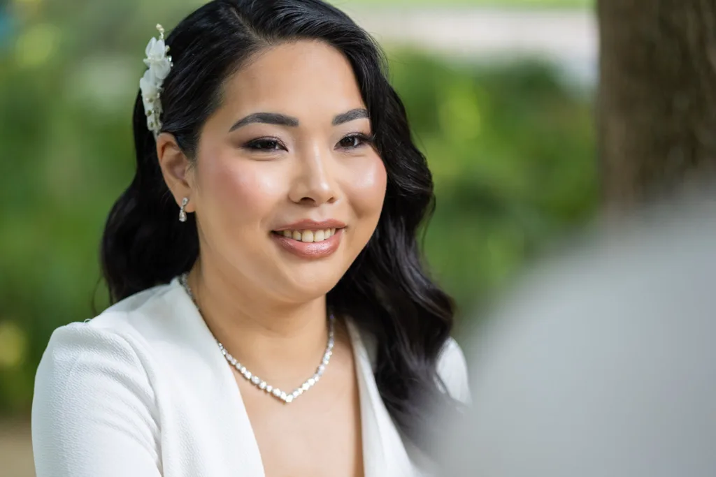 Portrait de Monita souriante, fleurs blanches dans les cheveux, le jour de son mariage