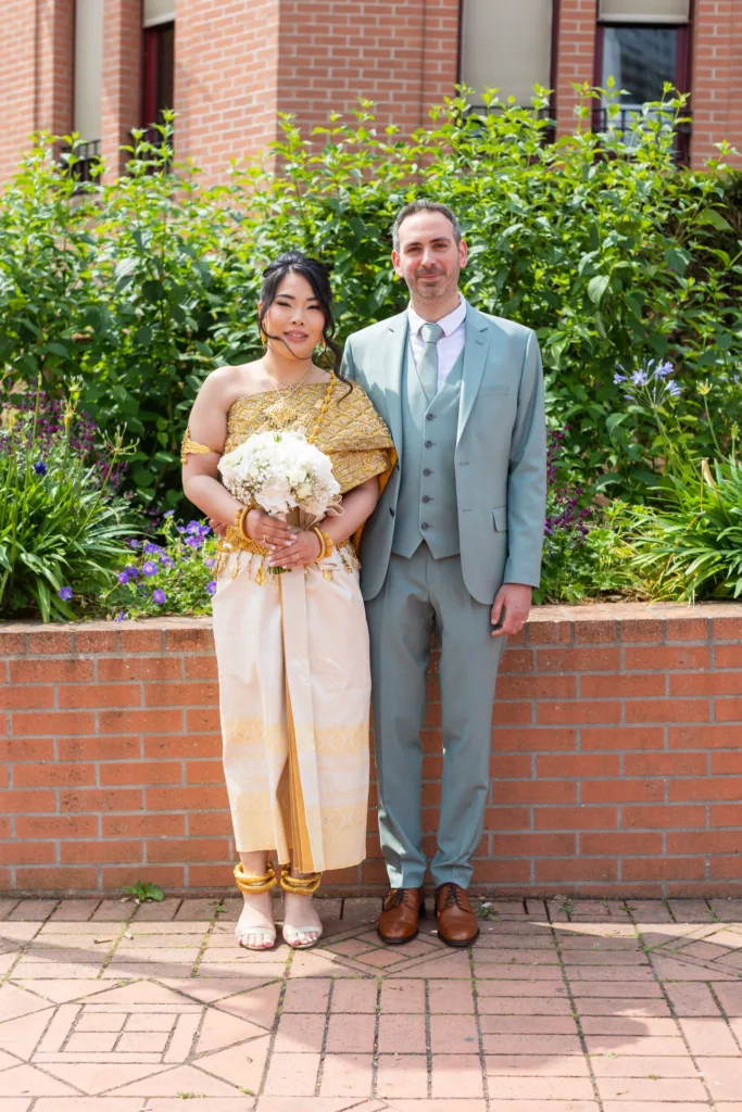 Monita en tenue traditionnelle cambodgienne et Jérémy en costume vert d'eau lors de leur mariage civil à Vitry-sur-Seine