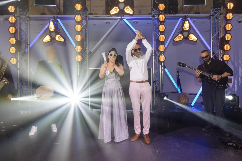 Monita et Jérémy en lunettes de soleil sur scène avec les musiciens pendant la soirée